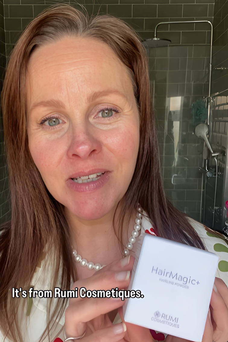 Smiling woman holding HairMagic+ hair powder for grey root touch-up and scalp-friendly coverage